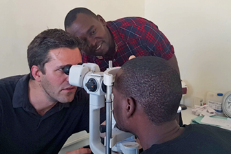 Foto (kleur) Verkerk en cataractchirurg Elton Munguya aan het werk